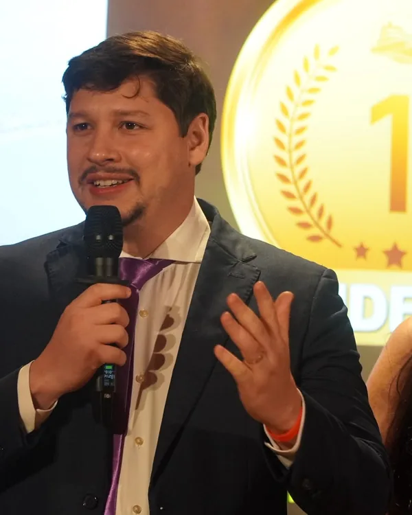 Caio Vinícius discursando no palco de uma premiação