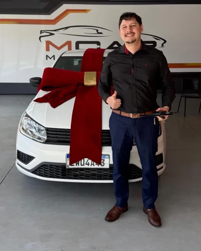 Caio Vinícius ao lado de um carro com laço de entrega